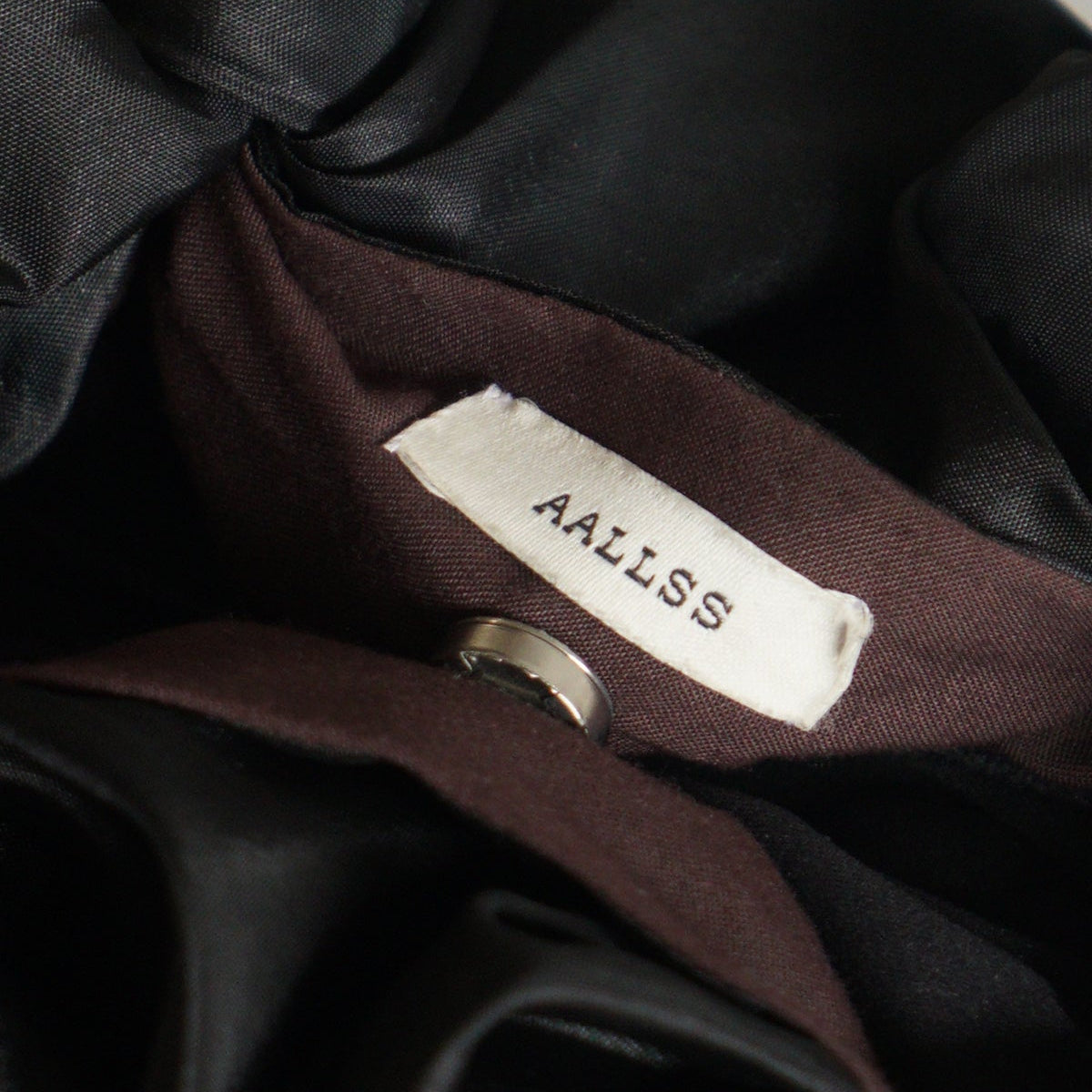 Close-up of a label on a dark fabric with 'AALLSS' branding.
