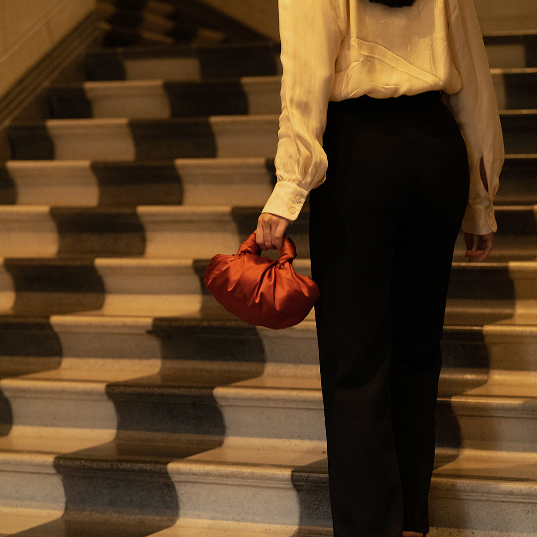 Person holding a red bag on a staircase