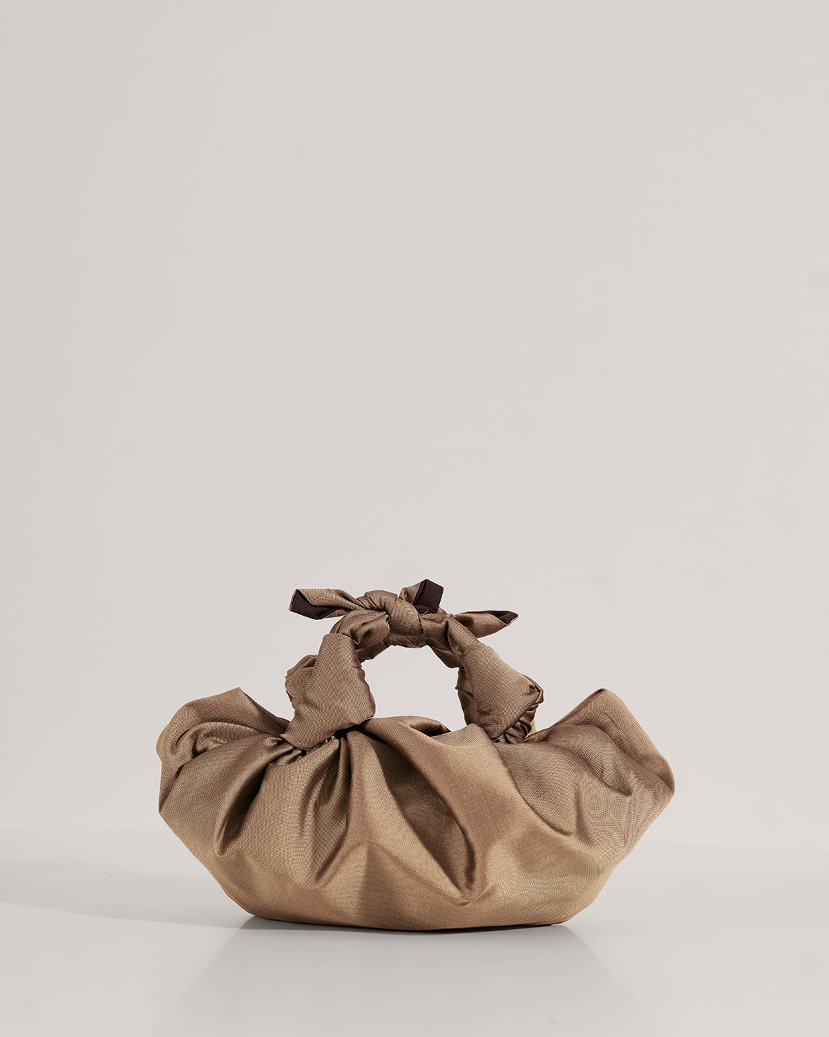 An earthy bronze VAST Silk Knotted Bag with hand-knotted top handles, displayed against a neutral background.